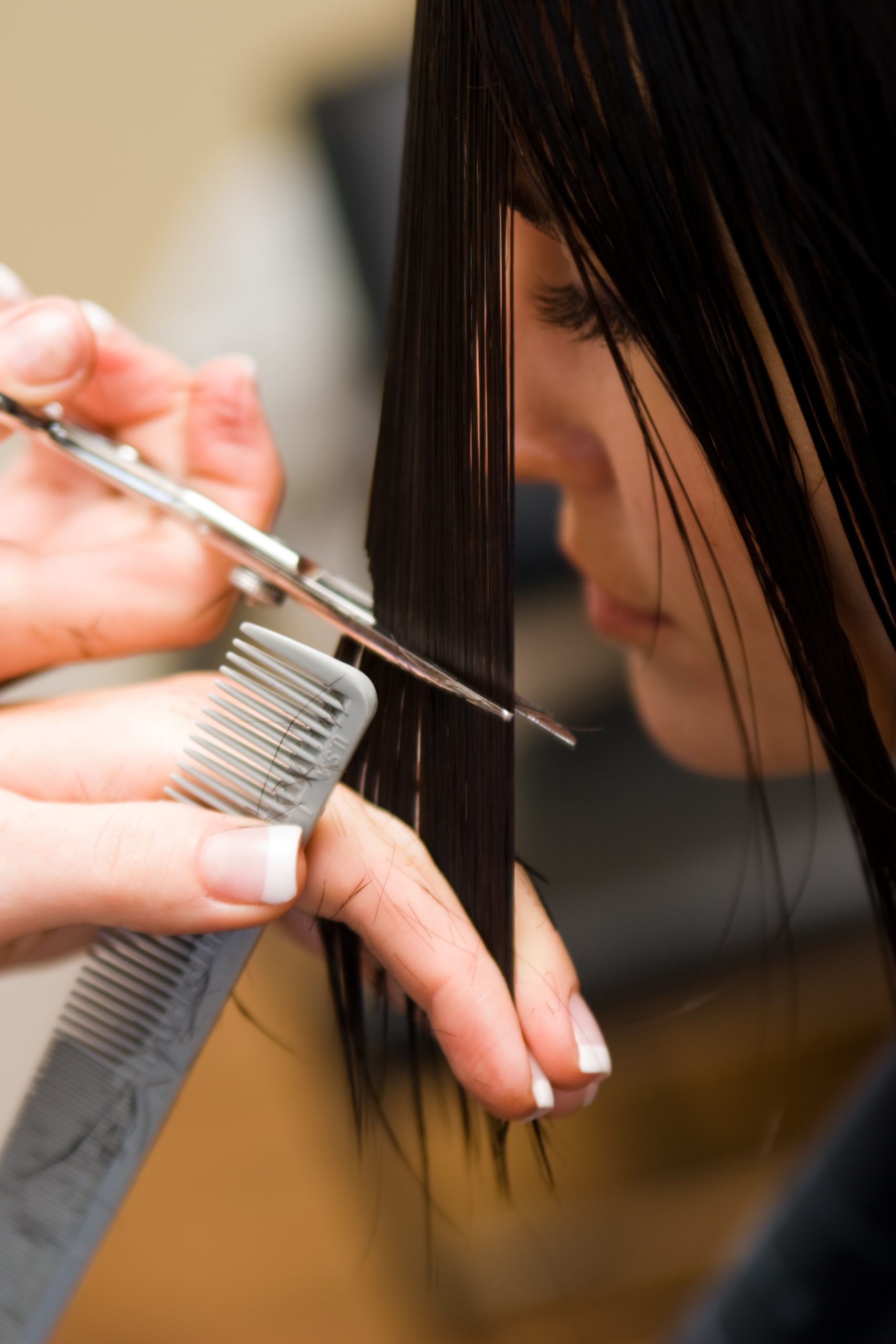 Young Lady Having Her Hair Cut With Scissors And A Comb